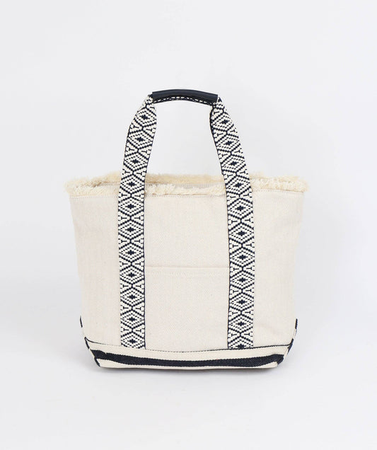 Front view of Off White canvas tote bag by Pia Rossini with black geometric pattern on handles against a white background