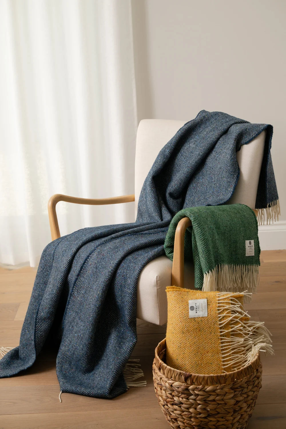 McNutt Arranmore blue lambswool tweed throw styled over an armchair in a contemporary interior