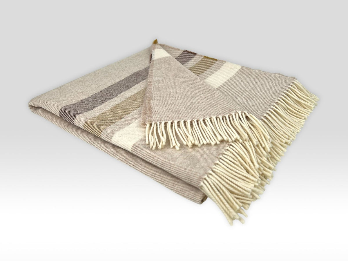 McNutt Toffee Roast throw close-up showing soft Merino lambswool texture, warm neutral bands and fringe