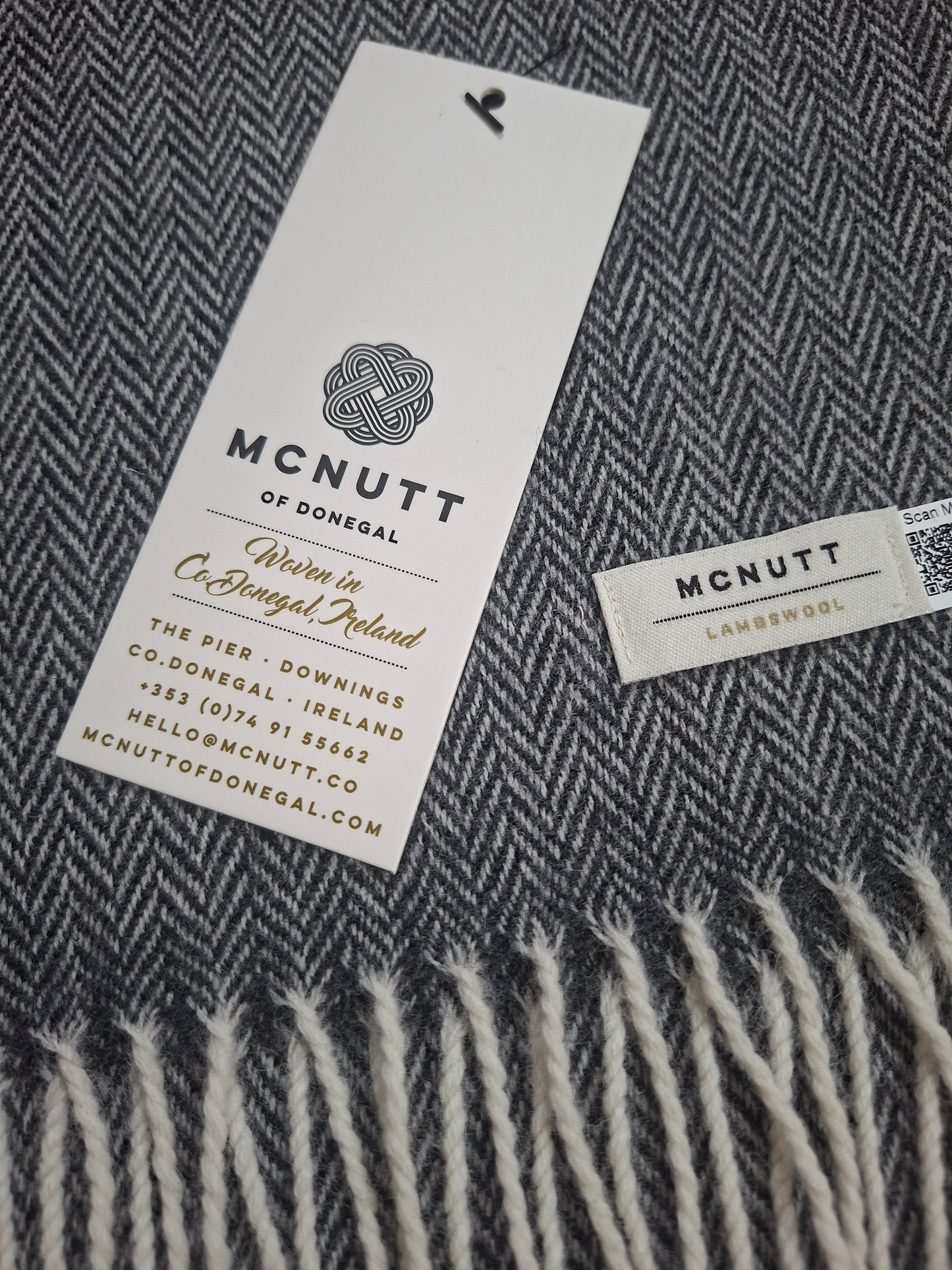 McNutt Charcoal Herringbone Merino Lambswool Scarf, showing grey woven pattern and fringed edge