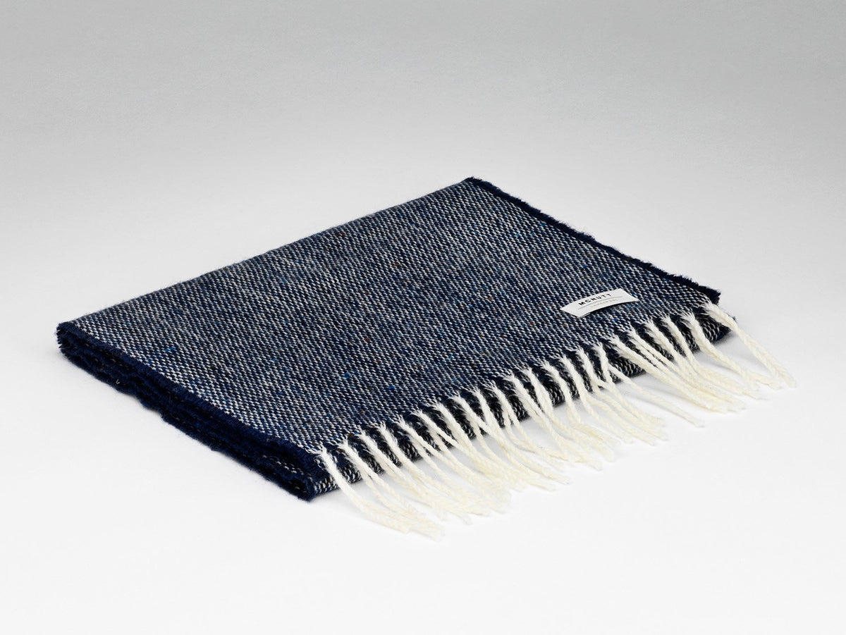 McNutt Donegal lambswool tweed scarf in navy, folded.